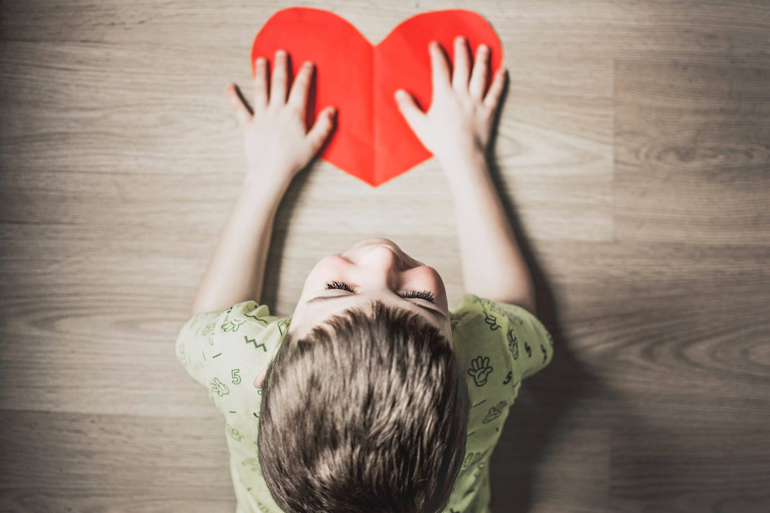 giving Tuesday - child with a paper cutout of a heart