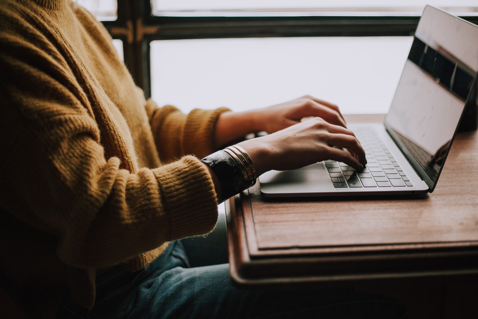 Woman typing on laptop at a table