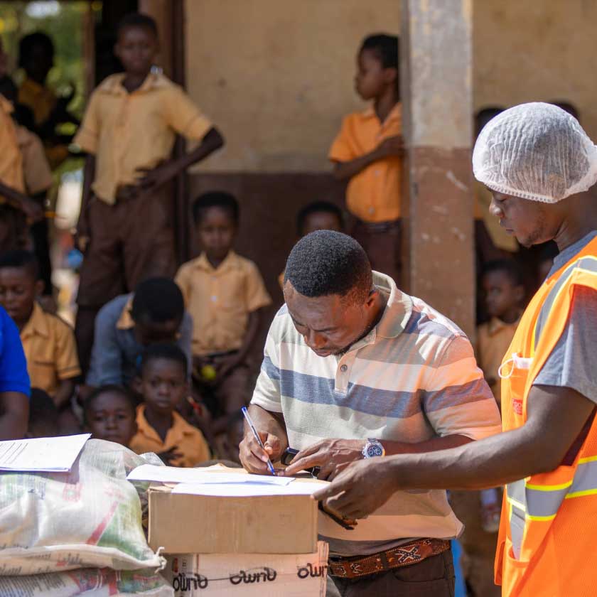 A man signing documents placed on top of the boxes