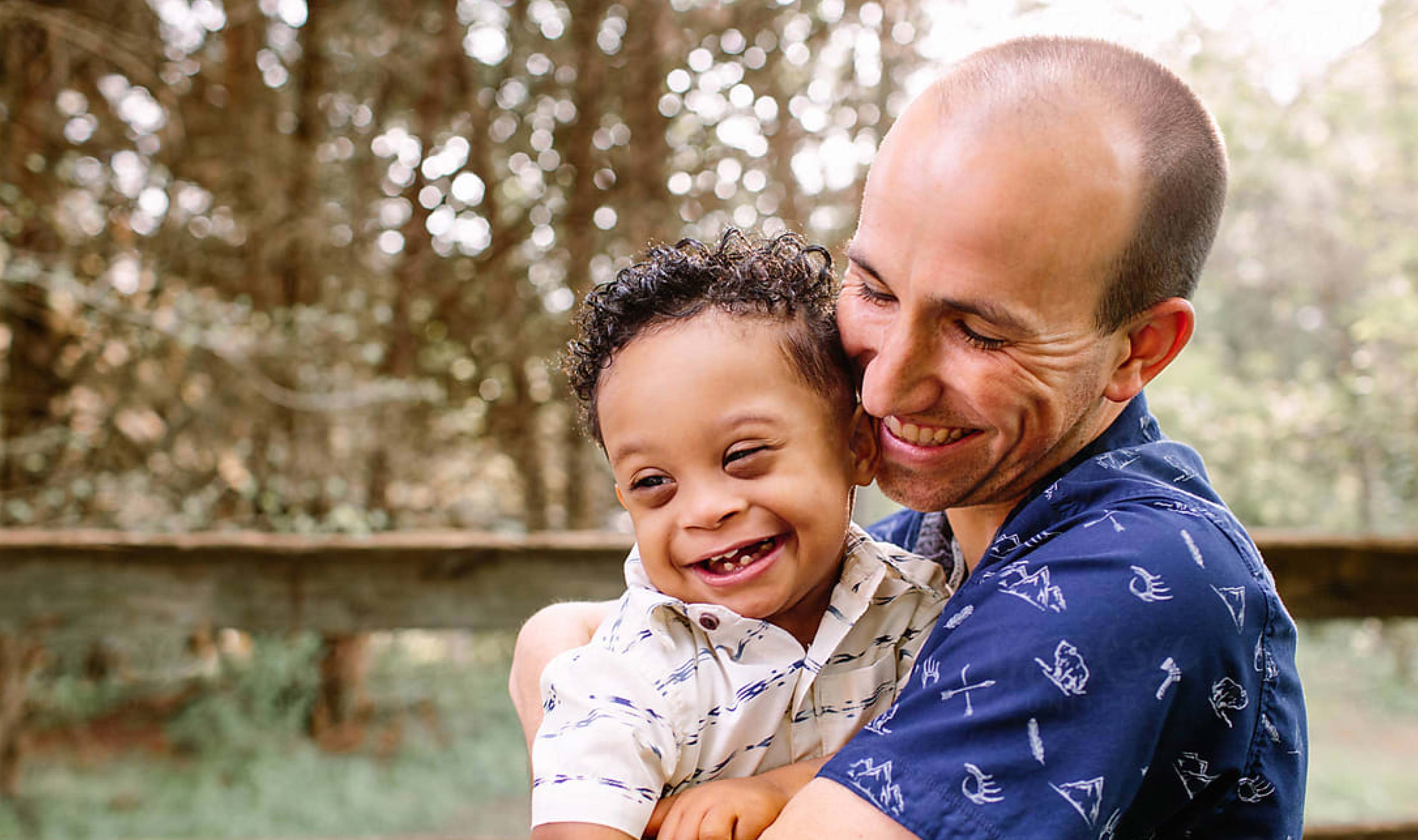 A man and a baby are smiling while the man is holding the baby