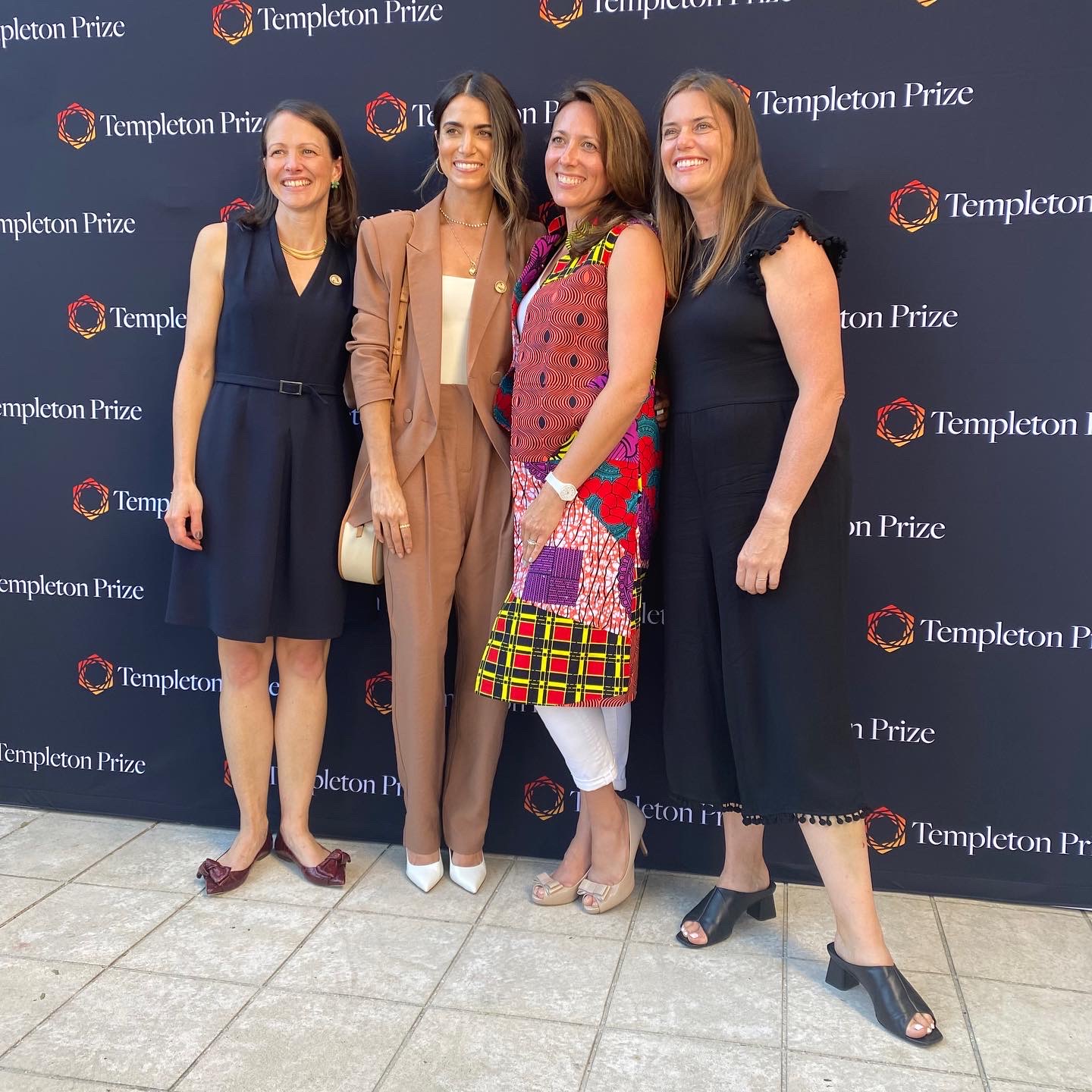 Nikki Reed and Templeton Prize Event team stand in front of a branded Templeton prize backdrop with the new logo