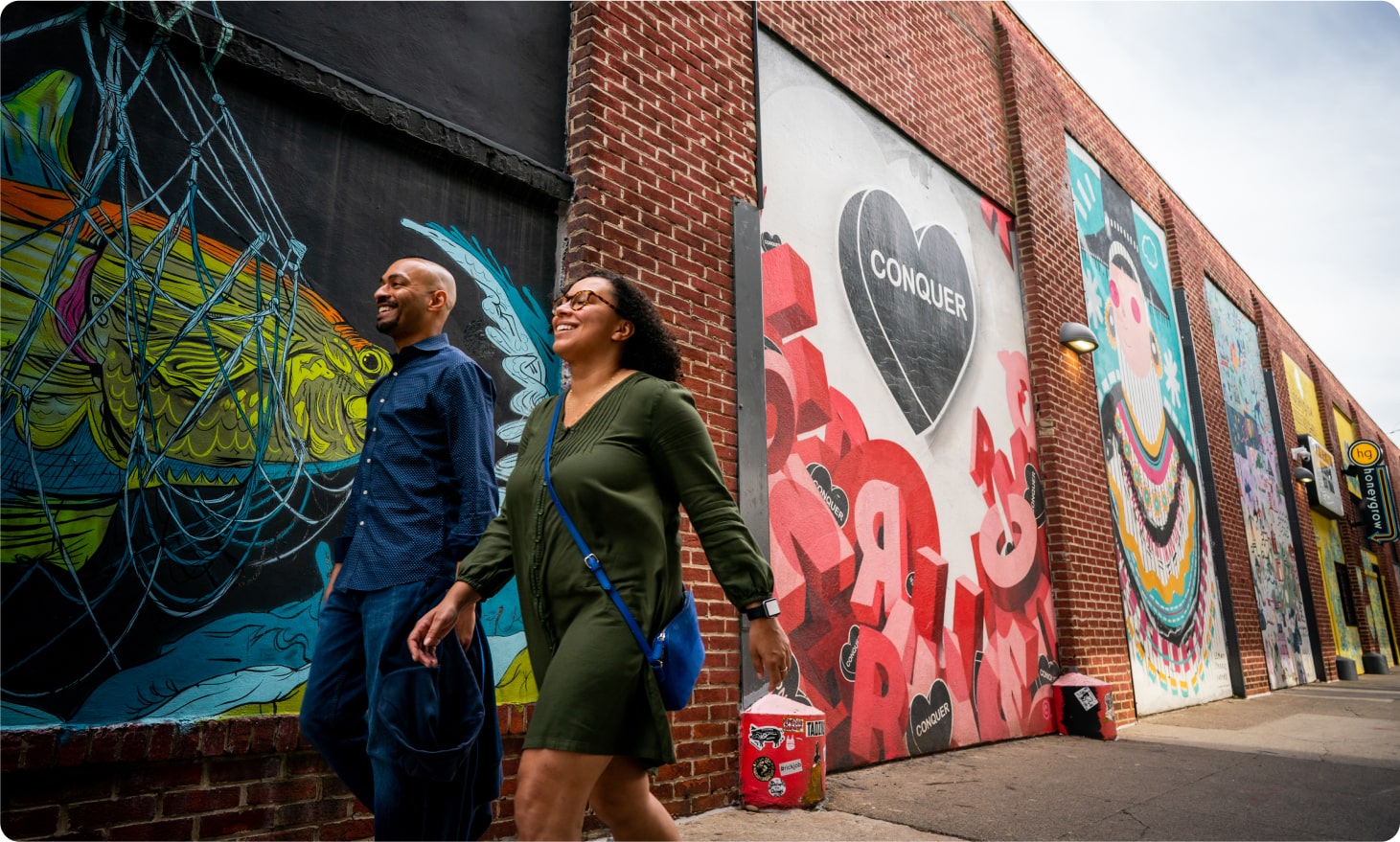 A couple is walking down the street smiling